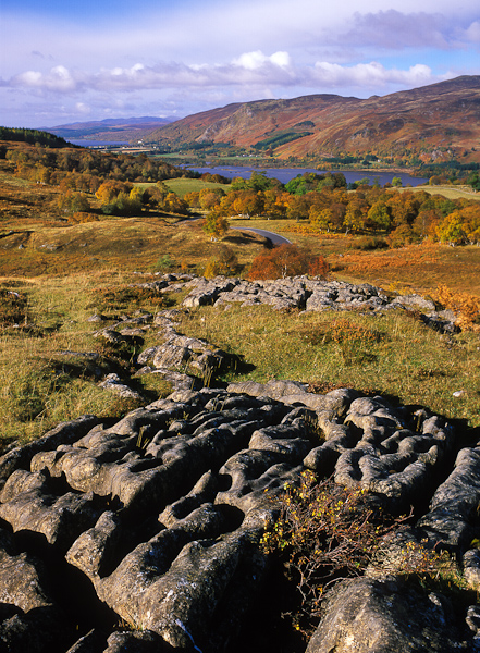 A classic Scottsih Autumn scene, with colourful trees and bracken on the hillsides and a loch in the distance. The rocky limestone...