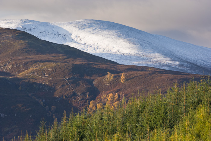 The first snows of Autumn have coated the hills which are lit by sunlight streaming through a gap in the clouds. I composed the...